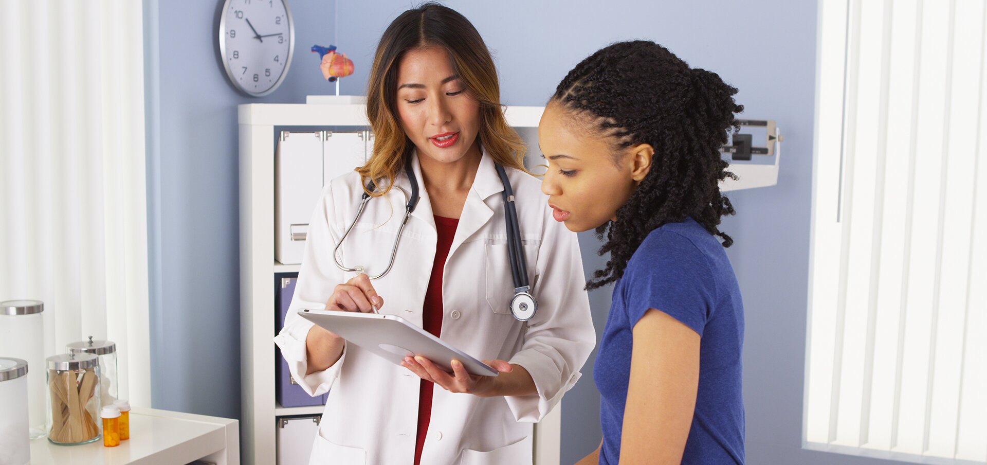 Asian doctor talking to black patient